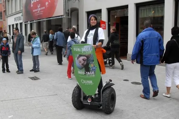 Segway mit Werbeschild in einer Fußgängerzone